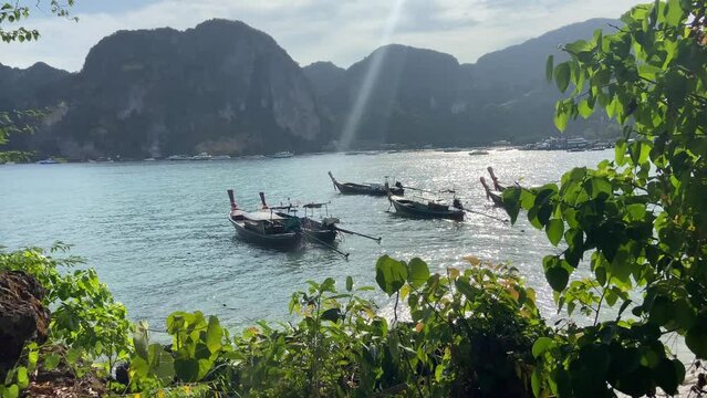 Traditional Thai long tail boats anchored in shores of Phi Phi islands, sunny day