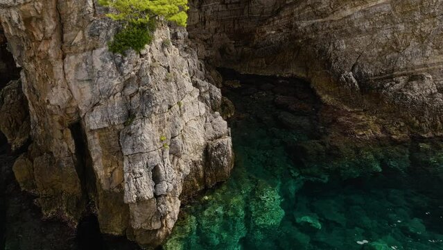 Kalamota Island, Adriatic Sea, Croatia - The Untouched Azure Waters Close to the Steep and Rugged Cliffs - Pan Up Shot