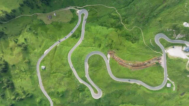 Aerial view of vehicles driving on the winding roads of Passo Gardena in the Dolomites Mountains, Trentino, South Tyrol, Italy. LuPa Creative.