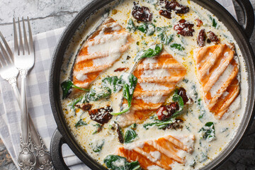 Marry Me Salmon smothered in a buttery, creamy sun-dried tomato spinach sauce closeup in the pan on...