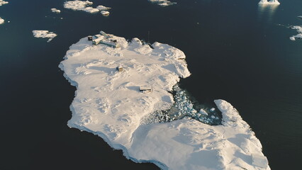 Top-down helicopter landing above Antarctic polar station - Vernadsky Base. Ocean water surface....