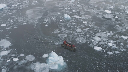 Zodiac Motor Boat in Icebergs, Tracking Aerial Top Down View. Expedition Rubber Transport Exploring...