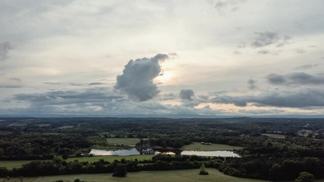 aerial hyperlapse shot looking towards the sunset as the clouds pass in the distance