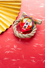 金色の扇と正月飾りと赤色の和紙の和風イメージ　