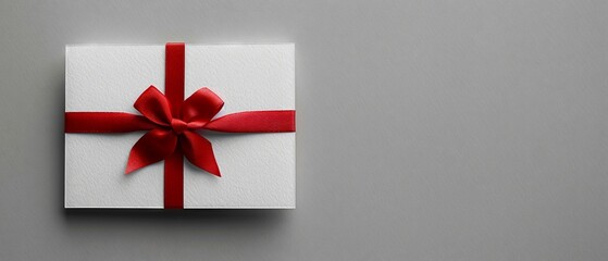 Sleek white gift card, tied red ribbon, grey background, subtle shadow, minimalist, text space