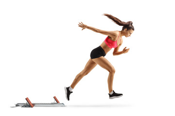 Full length profile shot of a female athlete starting a race with starting block