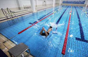 A child is diving in a swimming pool