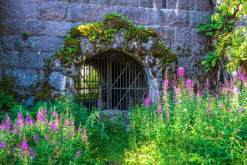 Tunnel entrance with an iron gate into an old fortress - 782839079