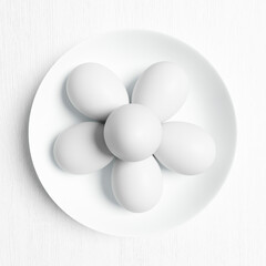 Painted Easter eggs lie on a white ceramic plate.