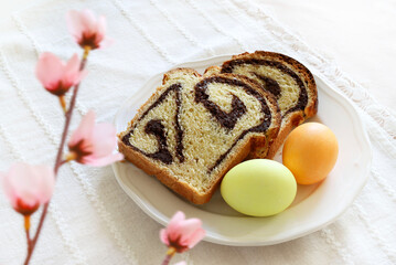 Cozonac, pane dolce tradizionale rumeno con noci e due uova di Pasqua isolate su sfondo bianco. Concetto di vacanza di Pasqua. - 782840040