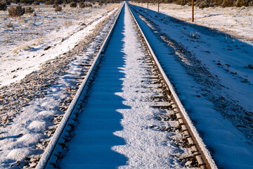 Dead straight single track railway line covered in snow on a frosty cold winter morning. Railroad...