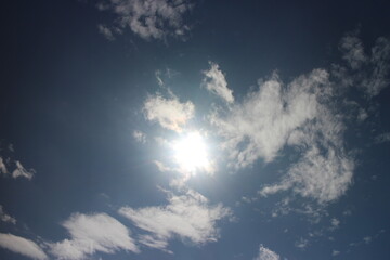 Naklejka na ściany i meble Clouds in the blue sky. Bright midday sun illuminates the space.