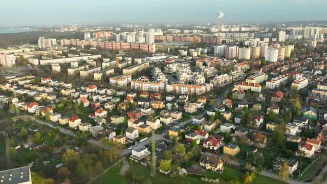 Aerial - panoramic aerial view of a mixed urban landscape during daylight, contrasting dense apartment blocks with a suburban area sprinkled with detached houses and verdant patches - Gdańsk Oliwa