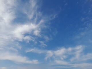 Beautiful white clouds on deep blue sky background. Large bright soft fluffy clouds are cover the...