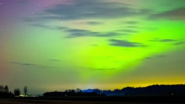 Northern lights show in multiple colors across Latvia countryside, aurora shimmer throughout the sky 