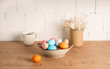 a clay plate with painted Easter eggs stands on a wooden tabletop. close-up. preparation for Easter, Christian Easter. home holiday concept, minimalism © Маргарита Трушина