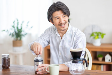 コーヒー豆を挽く男性