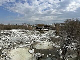 flood on the river in spring. ice floes float on the river against the background of a blue sky...