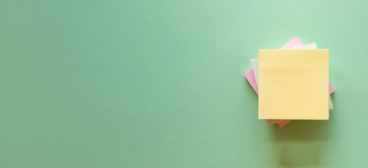 Empty yellow sticky note over green background.
