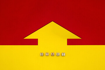 黄色の背景の矢印が赤い背景を指すSTARTの英語ブロック