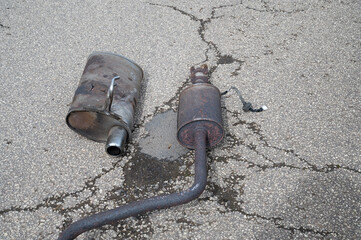 Broken exhaust and muffler of a car, rusted silencer fallen down on the road, breakdown of vehicle
- 782853656