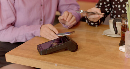Contactless mobile payment for the bill using a phone at the cafe. 
