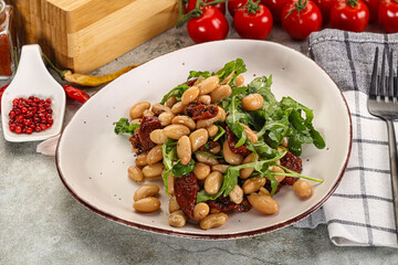 White canned beans with arugula and dry tomatoes