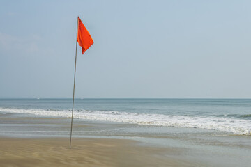 red flag on beach on sea or ocean as a symbol of danger. The sea state is considered dangerous and swimming is prohibited. - 782857461
