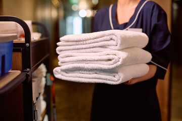 Close up of chambermaid with fresh towels in hotel.