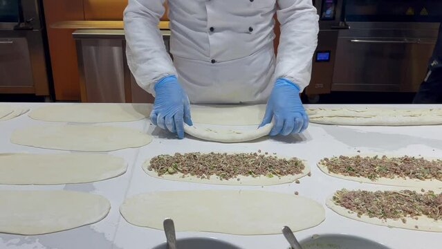 Faceless chef making pide with meat. Turkish style meat pie