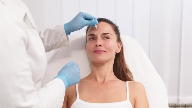 Close-up. Before the procedure for facial contouring or plastic surgery, the cosmetologist makes markings on the patient&rsquo;s face. Time to prepare for a cosmetic procedure.