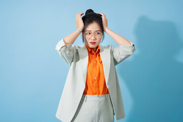 Photo of young Asian businesswoman on blue background