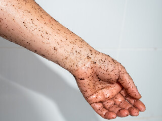 Woman hand applying coffee grounds scrub massaging cosmetic skincare exfoliates old skin cells