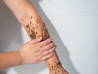 Woman hand applying coffee grounds scrub massaging cosmetic skincare exfoliates old skin cells