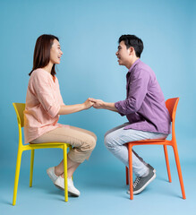 Photo of young Asian couple on blue background