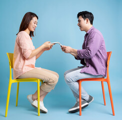 Photo of young Asian couple on blue background