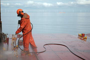 Safety Equipped Crew Seaman Working On Deck With Jet Water Blast Machine Gun To Remove Prevent...