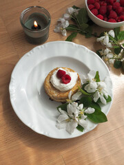 Pancakes with cream, raspberries and flower decoration