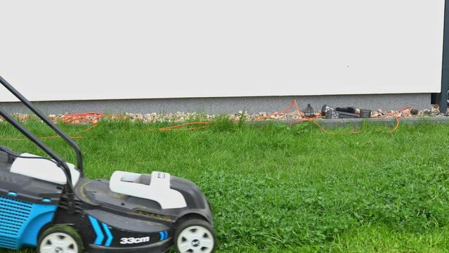 Lawn mower cuts the grass on the lawn in spring 