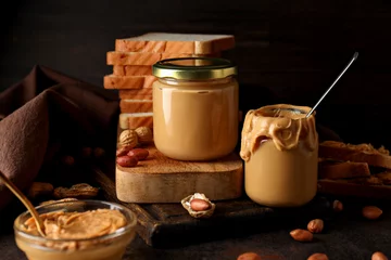  Peanut paste in a glass jar, on a dark background. © Atlas