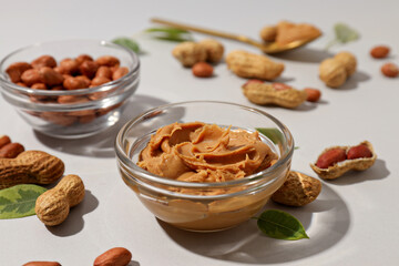 Peanut paste in a transparent plate, on a light background.