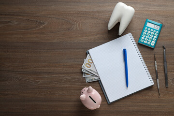 Tooth, dental instruments, piggy bank and cash, notepad and calculator on wooden background, space...
