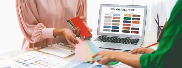 Cropped imaged of professional interior designers choose appropriate color from color palette with...