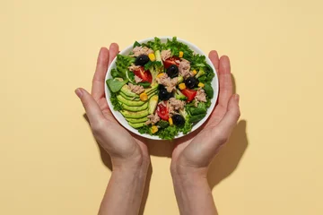  Salad with tuna on a yellow background. © Atlas