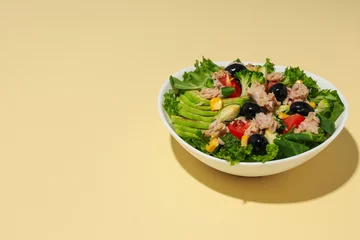  Salad with tuna on a yellow background. © Atlas