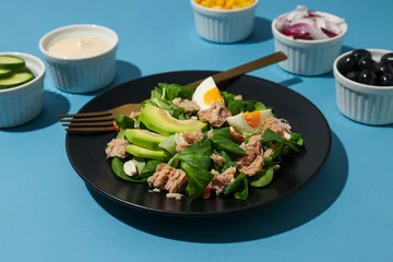  Salad with tuna on a blue background. © Atlas