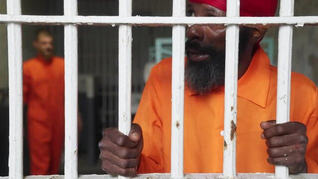 Black Male Man Prisoner in Orange Jumpsuit Jail Prison Cell