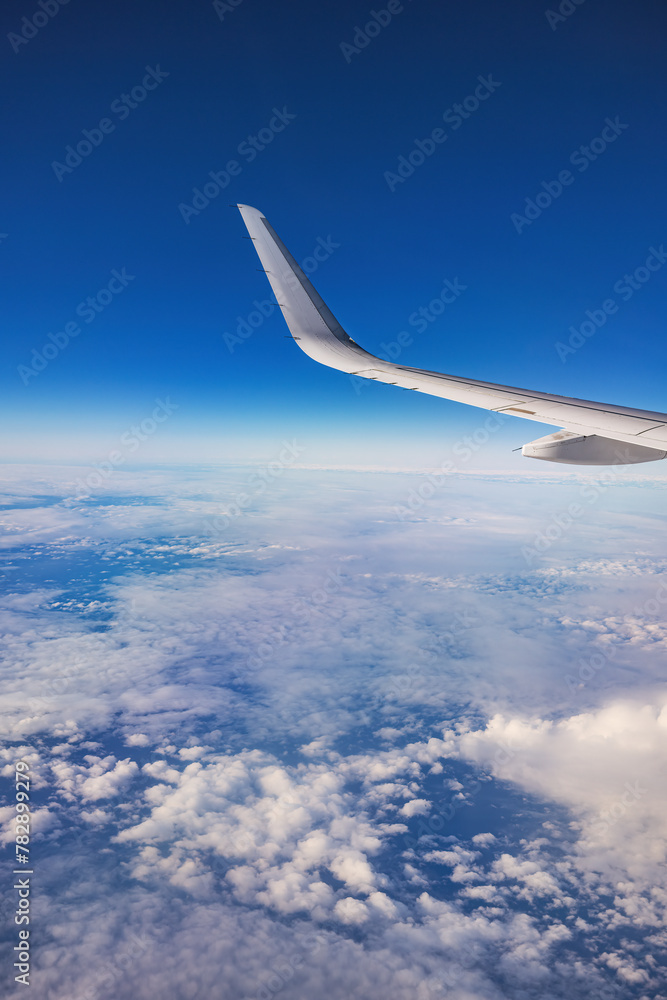 Poster Airplane flying over color sky clouds during scenic sunset or sunrise cloudscape, view from plane window of wing turbines and horizon