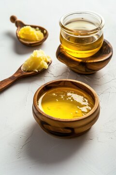 Glass bowl of pure honey with spoon on white background, closeup image.