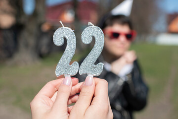A woman holding birthday numeral candle	